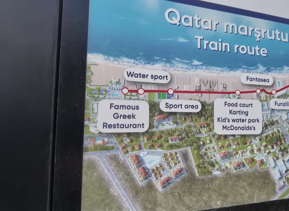 Стенд «Qatar marşrutu / Train route»: маршрут детского поезда вдоль пляжной линии — от Start к Famous Greek